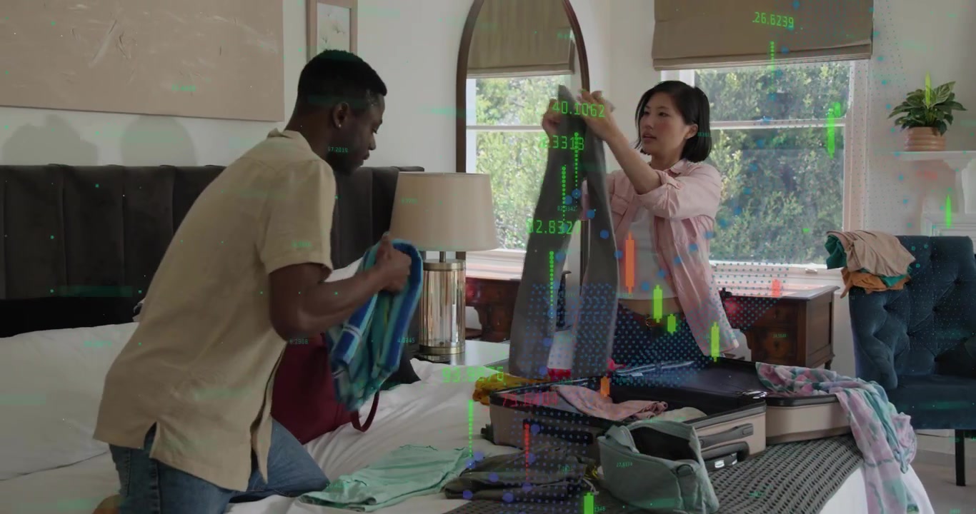 Man picking striped shirt and handing to woman for packing into suitcase, filling case for travel