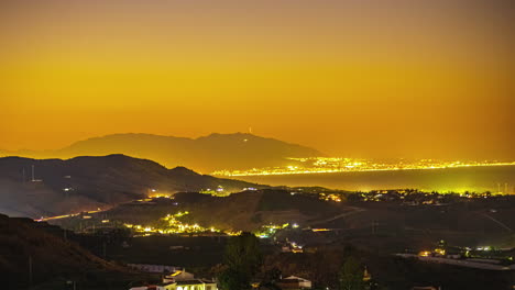 Hermosa-Ciudad-Costera-Con-Luces-Nocturnas-Durante-El-Amanecer,-Vista-De-Lapso-De-Tiempo