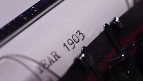 year 1903, typing on blank white paper in vintage typewriter, close up