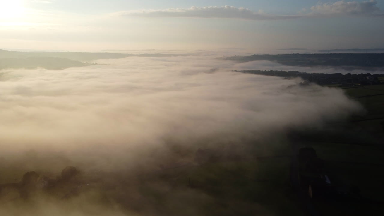 Establishing shot, Foggy morning over the Yorkshire Dales, meadow near a rural village, aerial view landscape