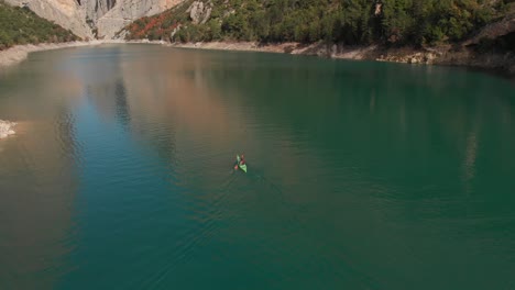 Aerial-drone-shot-following-a-kayak-in-the-middle-of-a-strait-Revealing-a-stunning-landscape