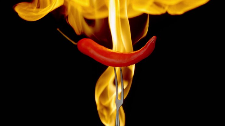 Spicy Red Chili Pepper On A Fork Spinning In Explosive Flames In Slow Motion, Macro
