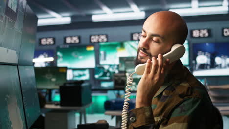 Military-soldier-in-mission-control-center-answering-telephone-call