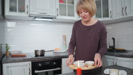 young woman happily preparing dinner in cozy modern kitchen with candle flame, cooking pot on induction stove, stylish interior cabinets, fresh ingredients, and elegant marble countertop
