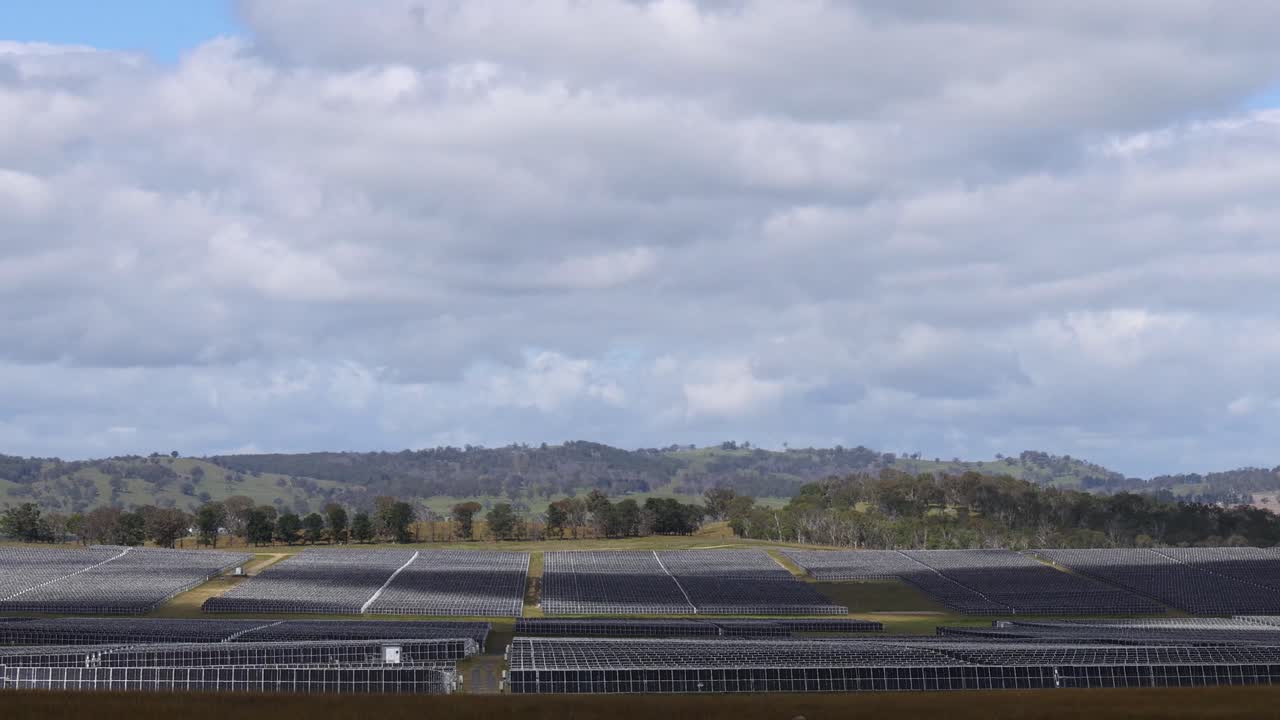 granja de paneles solares expansiva bajo cielos nublados