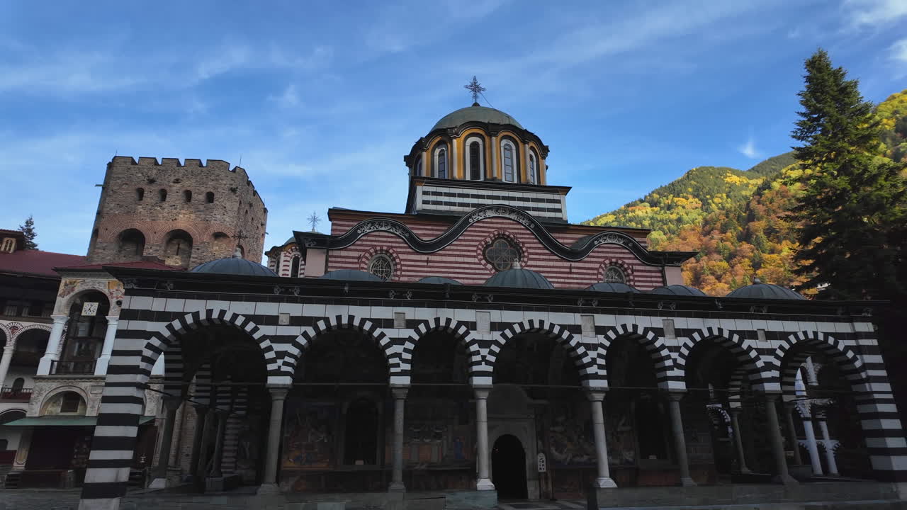 Majestic Rila Monastery stands against the backdrop of autumnal mountains, showcasing its intricate architecture and spiritual significance