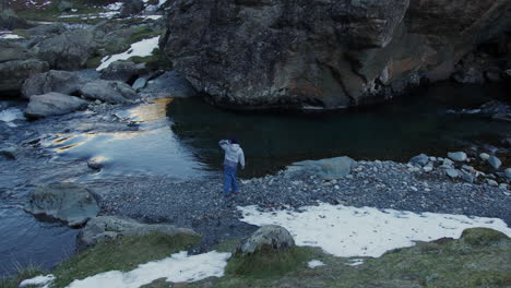 child by a winter stream in a mountain valley