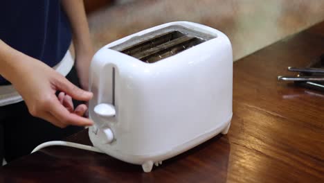 person toasting bread in a white toaster