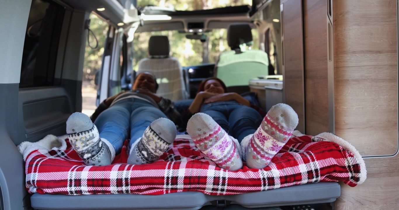Due persone che si rilassano su un letto all'interno di un camper