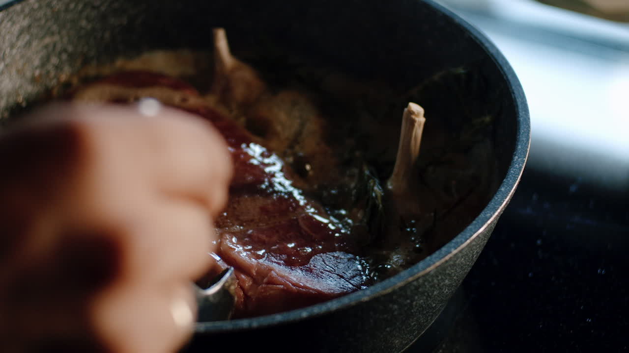 Mouthwatering scene of spoon basting hot molten butter over steak in pan
