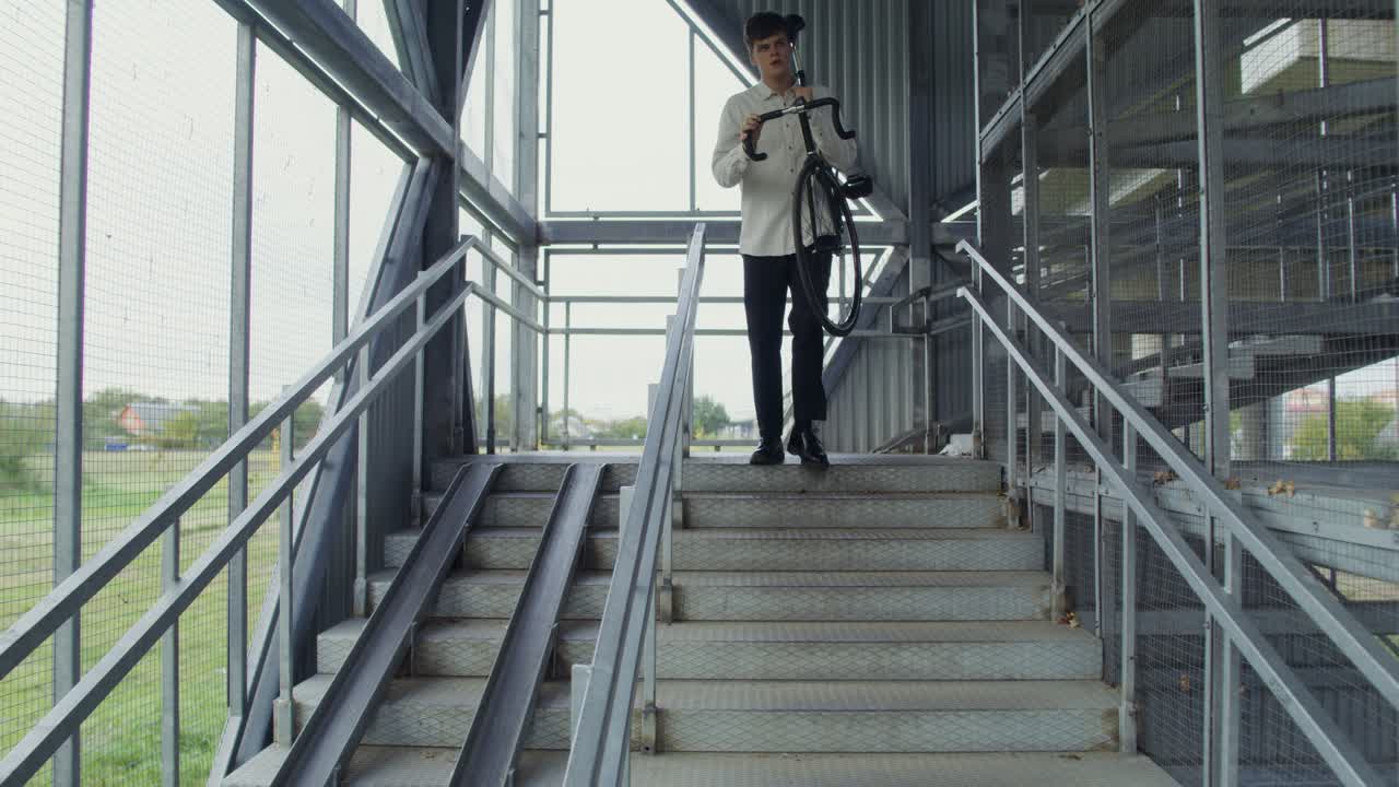 남자 가 자전거 를 들고 금속 계단 을 올라간다