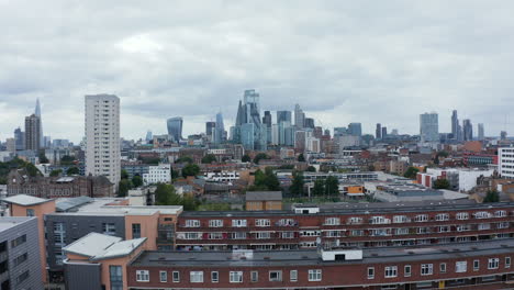 Rising-shot-of-urban-development-at-Watney-Market.-Revealing-downtown-skyline-with-tall-office-buildings-in-City-financial-hub.-London,-UK