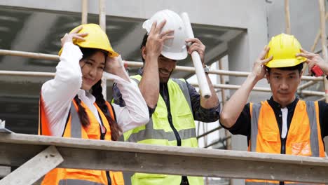 civil engineers prepares to work with team on building site while wearing a safety helmet on his and her head.