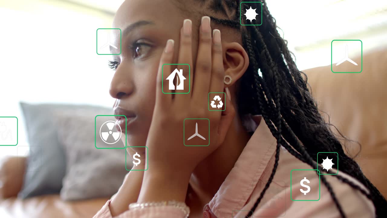 Woman cupping cheeks on couch, animated energy icons appearing and drifting, suggesting reflection