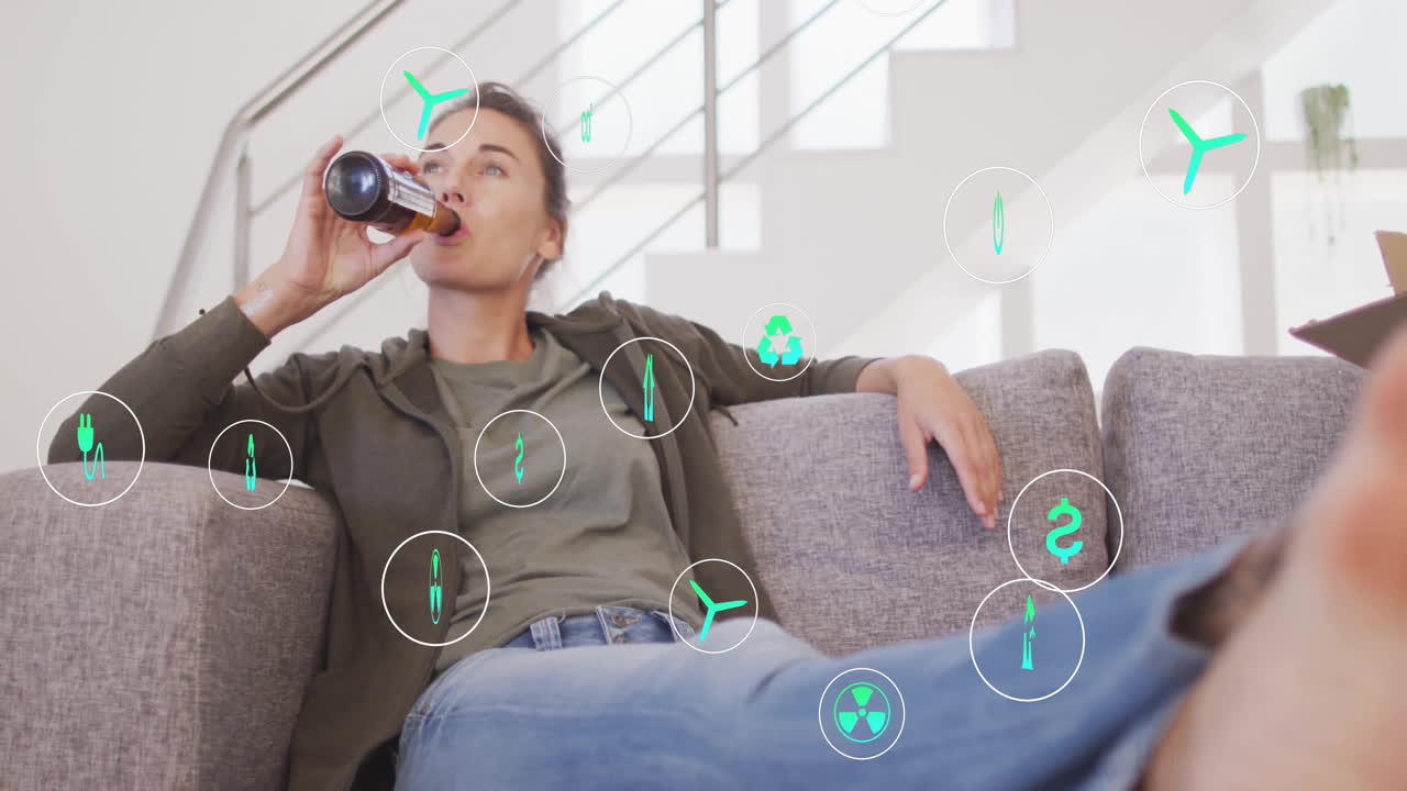 Woman reclining on couch drinking from bottle in modern room, showing floating energy icons