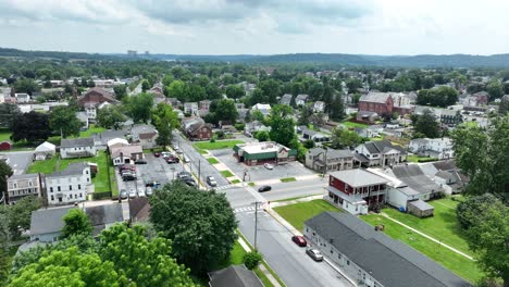 drone flight over american town named middletown, pa in summer. water tower in center of small neighborhood. aerial birds eye shot. cloudy day with green yards