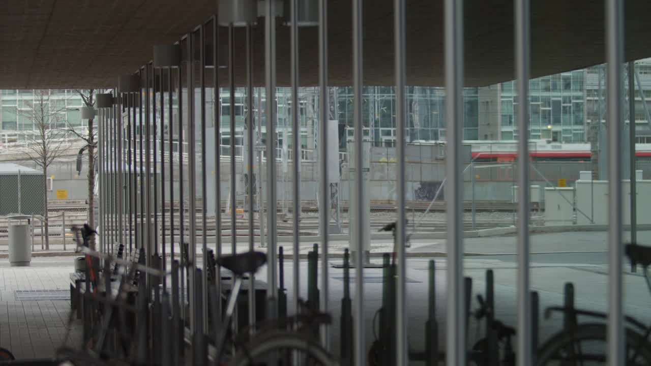 Cinematic slow motion medium wide 4K with parallax motion of Barcode building window reflecting public commerce train leaving the central train station, in Bjørvika Oslo Norway