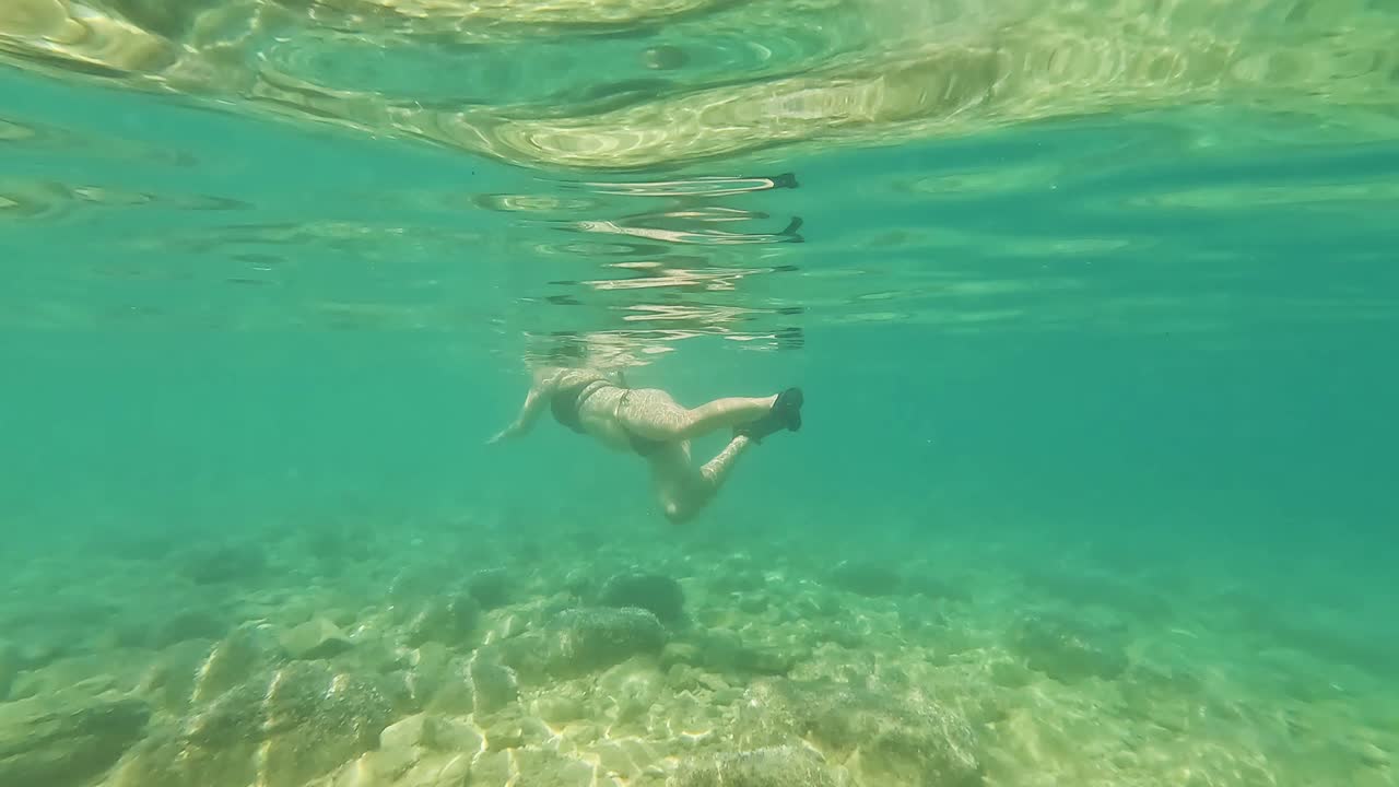Underwater Shot of Young Woman Swimming in Adriatic Sea in Croatia Summer Scene Featuring Bikini Clad Swimmer in Clear Blue Water Captured in Serene Mediterranean Coastal Setting