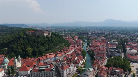 magnificent aerial view of castle and cityscape of ljubljana in slovenia. wide shot. sunny day with blue sky in summer. historic red brick buildings and orange roof