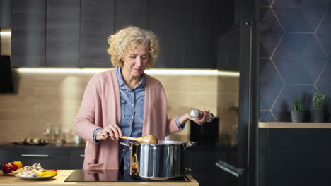 senior woman cooking soup in the kitchen