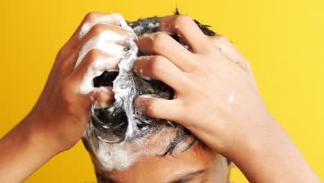 young men washes h his hair with shampoo