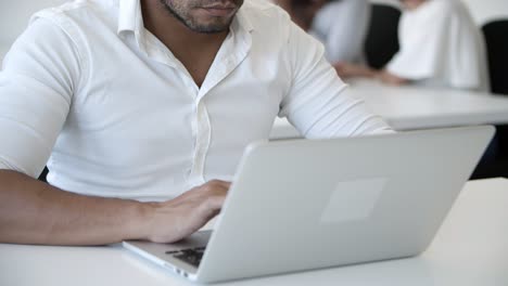 Cropped-shot-of-focused-young-man-typing-on-laptop