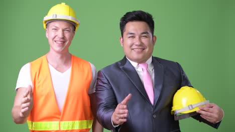 scandinavian man construction worker and asian businessman working together