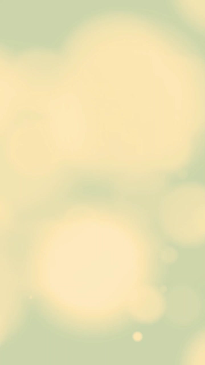 Soft Yellow Bokeh Lights Floating on Light Green Background