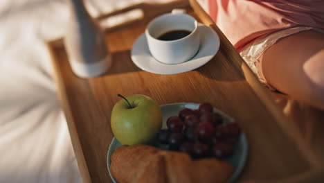 female hands typing smartphone in bed closeup. cozy breakfast coffee in bedroom