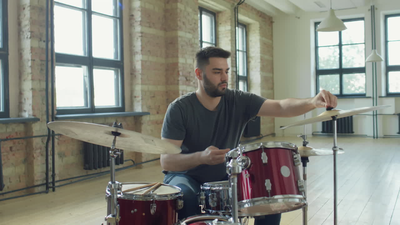 Drummer Mounting Hi-Hat on Drumset Stand