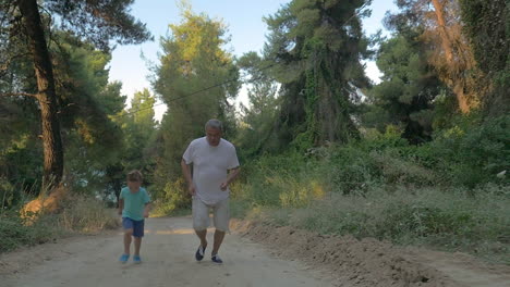 abuelo y nieto corriendo en el bosque