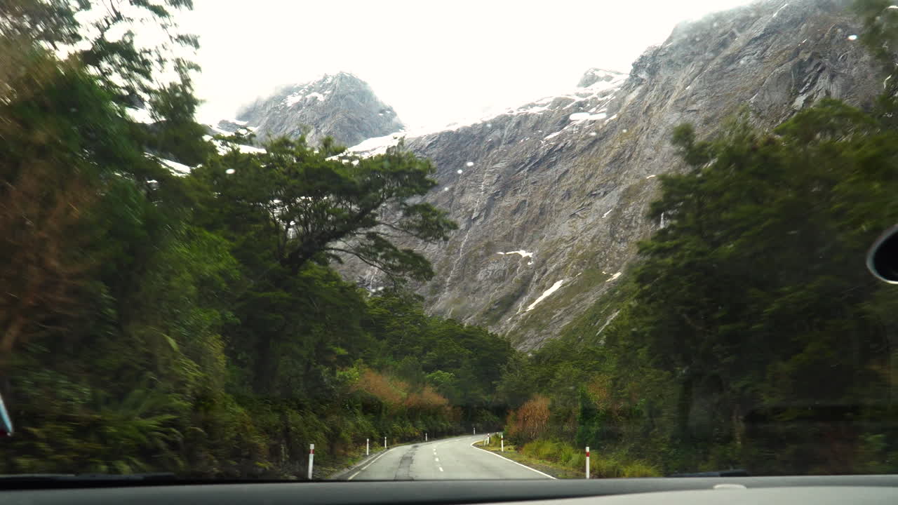 낮에 뉴질랜드 밀포드 사운드로 이어지는 피오르드 랜드 국립 공원의 도로를 운전하는 동안 촬영
