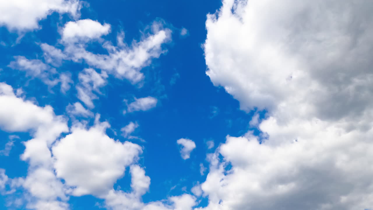 Bright azure skies hidden behind the soft white clouds. Cumulus clouds timelapse.