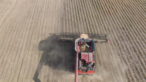 Aerial-Ascending-Shot-of-Combine-Harvester-Harvesting-Dry-Soybeans-on-Rural-Farm-Field