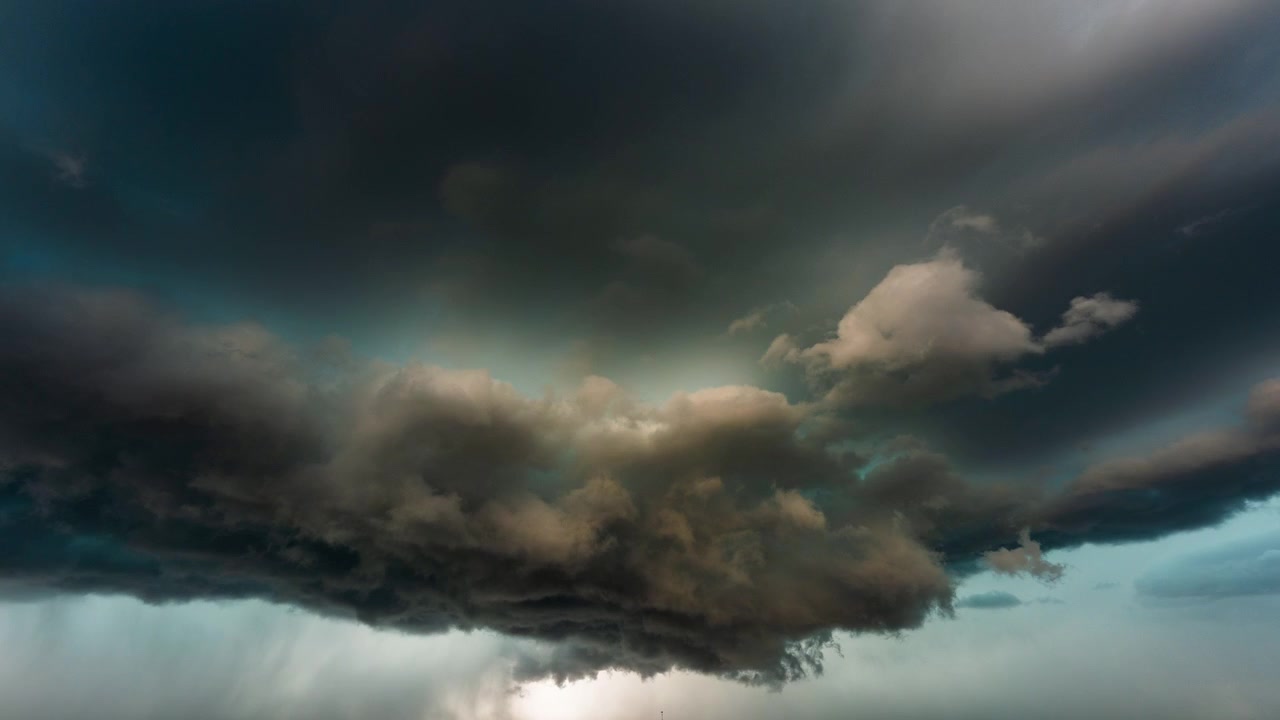 Heavy storm clouds drifting across ominous grey sky weather background