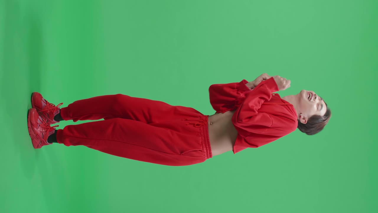 Full Body Of The Smiling Asian Transgender Male Dancing Sides While Standing In A Green Screen Studio