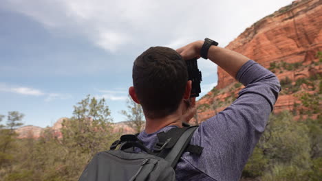 Joven-Fotógrafo-Alegre-Tomando-Fotografías-Con-Cámara-Digital-En-Las-Montañas-Del-Desierto-De-Sedona,-Arizona