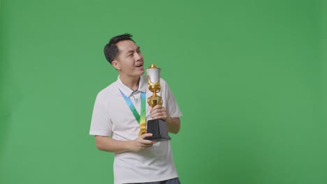 man celebrating victory with trophy and medal