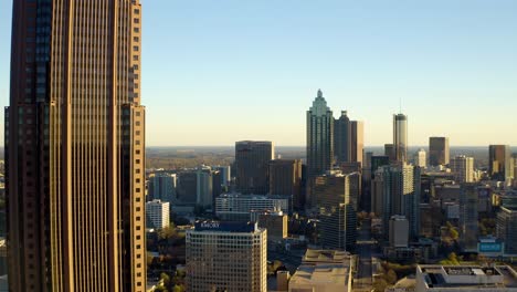 Aerial-drone-shot-slowly-ascending-alongside-the-Bank-of-America-skyscraper-in-downtown-Atlanta,-Georgia-with-other-downtown-highrises-in-the-background