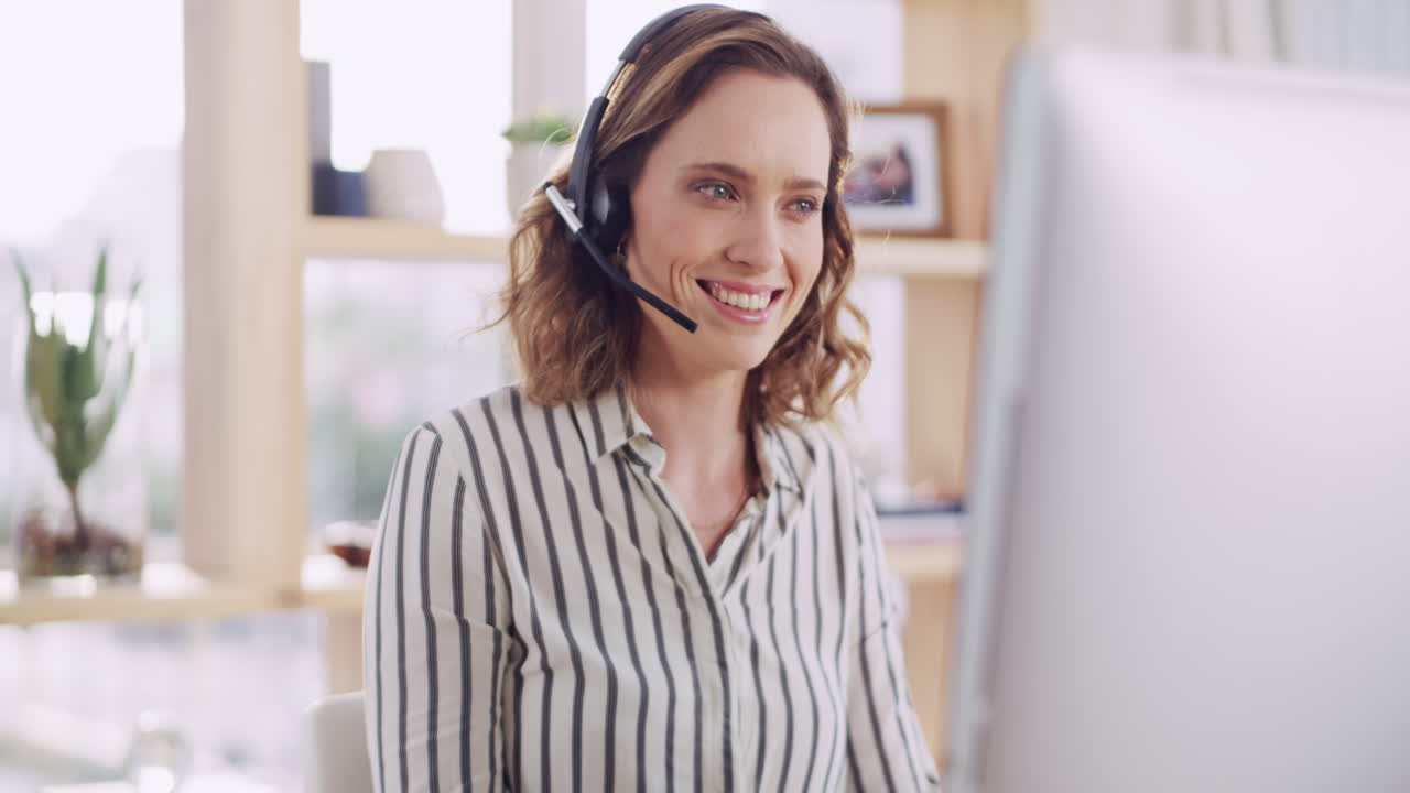 Donna in ufficio che usa le cuffie e il computer