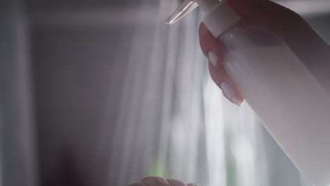 mujer frotando jabón en la mano exprimido de la botella. dama vertiendo gel blanco de la botela transparente. mano de mujer con movimientos suaves frotando gel