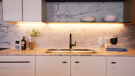 panning shot of a well-lit, white and bright modern kitchen with stylish design