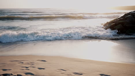 sunset glow on secluded beach with footprints