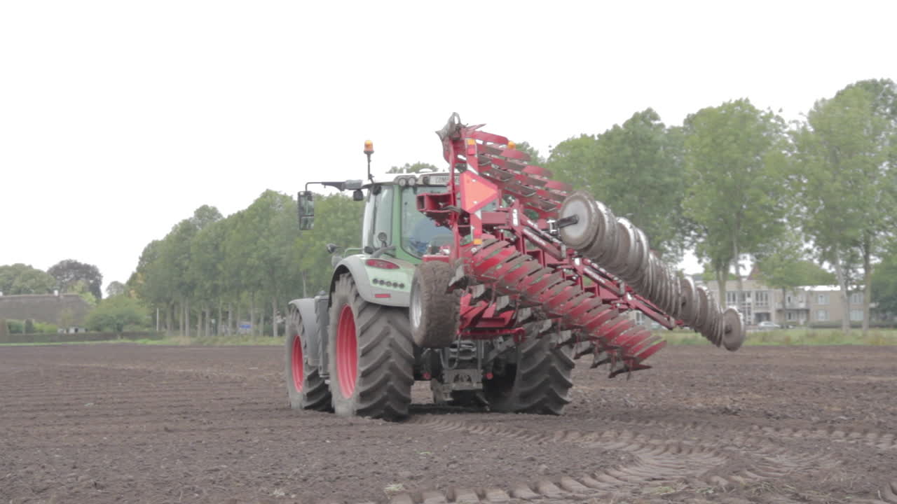 들판에 큰 쟁기가 있는 트랙터