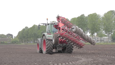 tractor with big plow standing on field