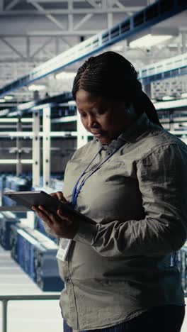 vertical video team of data center technicians checks ai dashboard using laptop