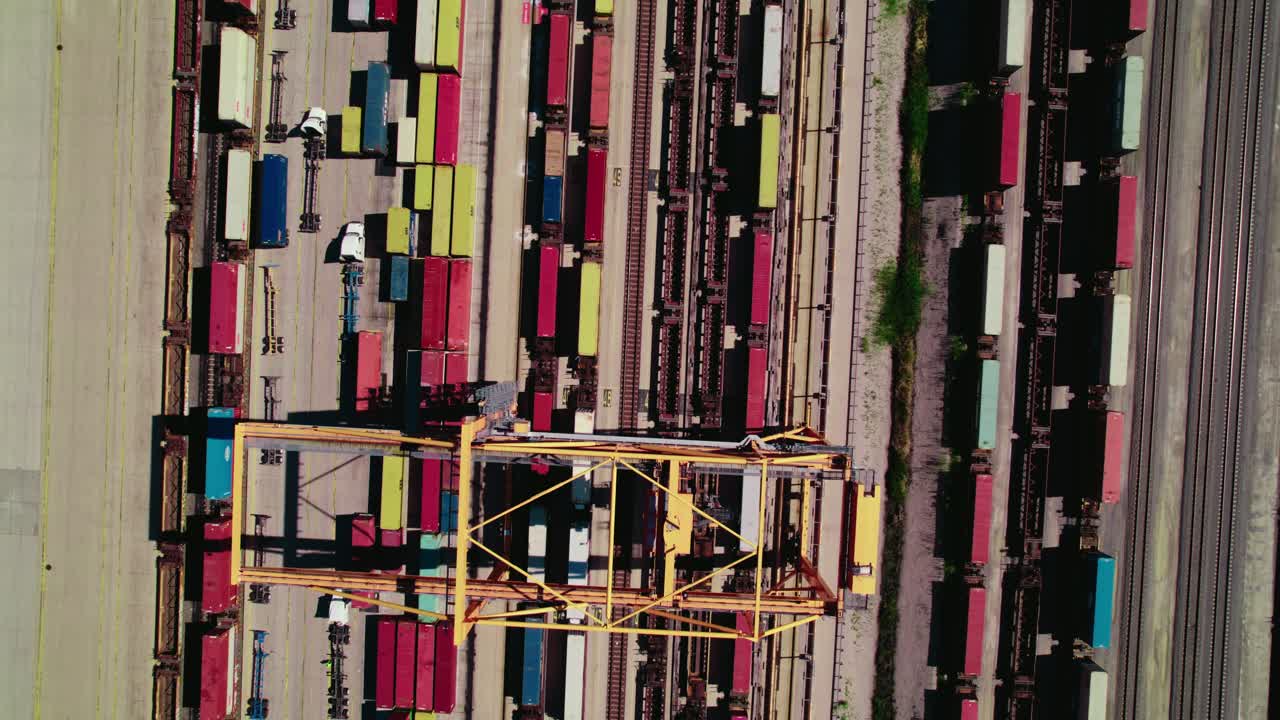 Aerial top view over a rail terminal full of containers for commercial distribution and shipping