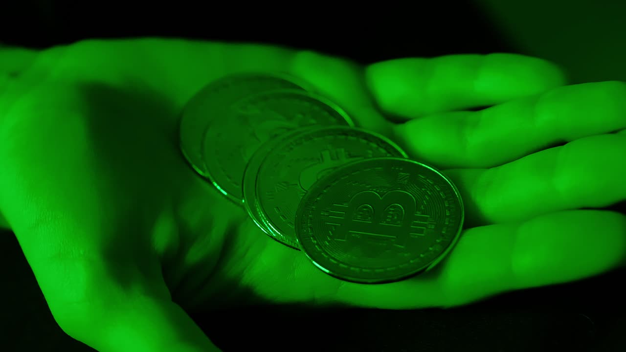 Woman stacks shiny Bitcoins on hand in green glow showing crypto optimism