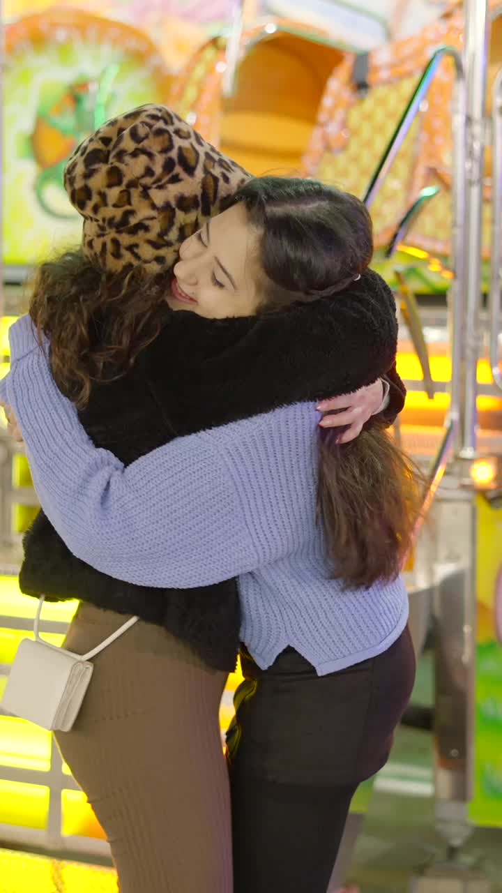 Happy friends hugging at an amusement park
