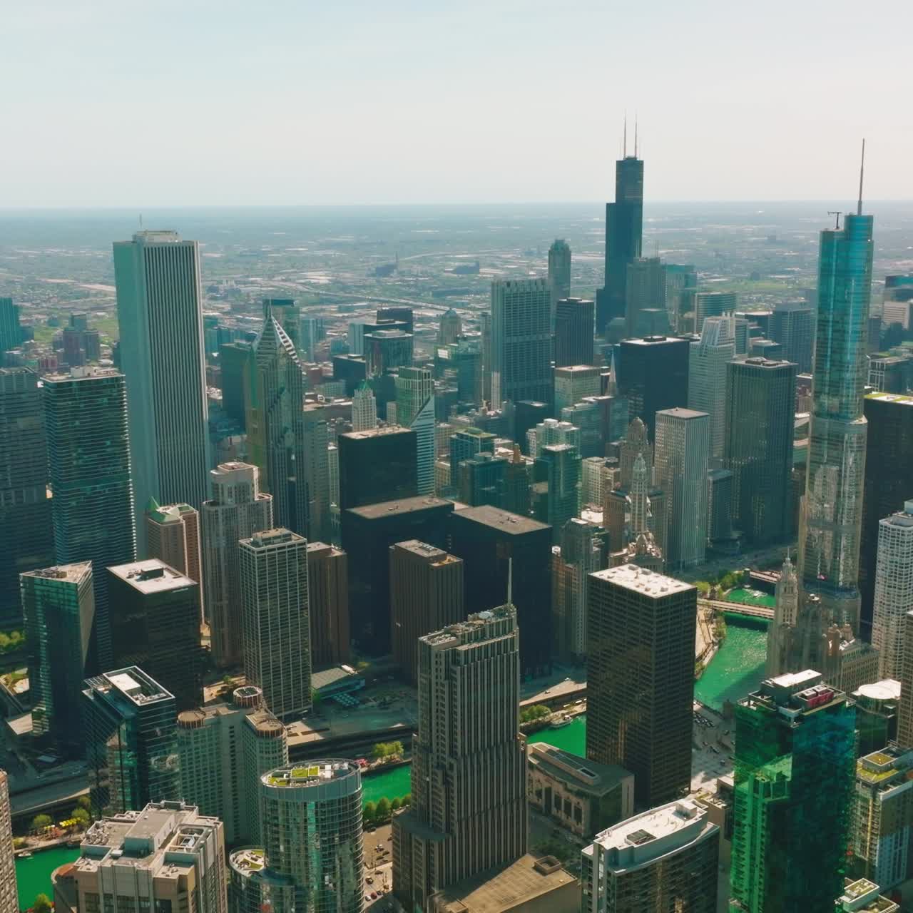 Sunlit Chicago at daytime. Beautiful scenery of the city from aerial perspective. Chicago River flowing among the wonderful skyscrapers